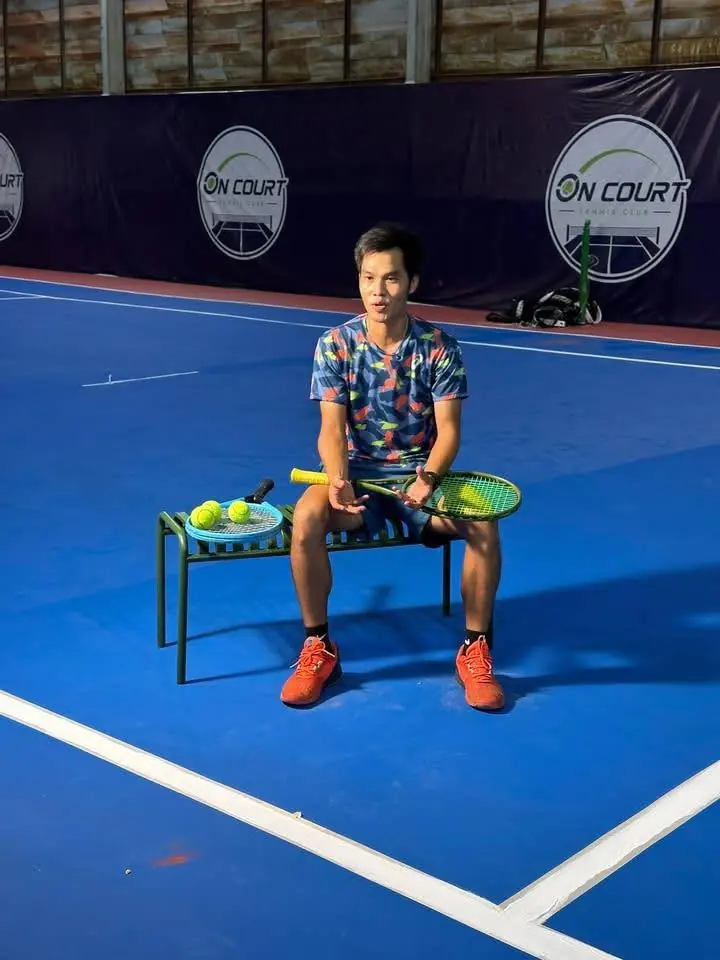 โค้ชมาร์ค Worradit Pathamarot นั่งข้างตะกร้าลูกเทนนิสในคอร์ต On Court