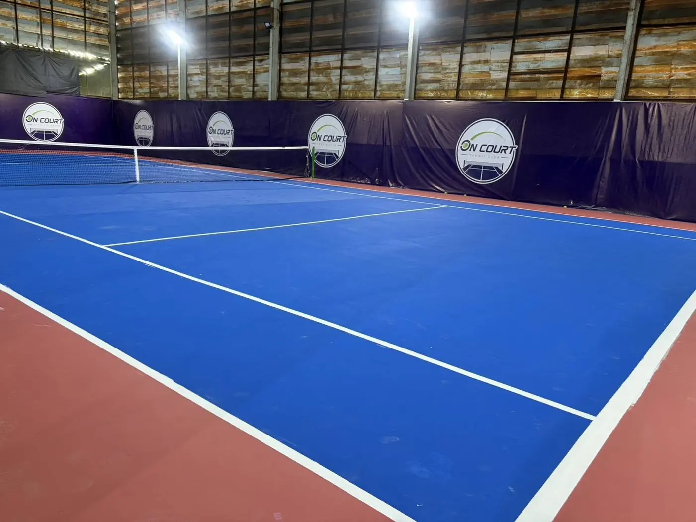 พื้นคอร์ตฮาร์ดสีน้ำเงินและผนังสีม่วงของ On Court
